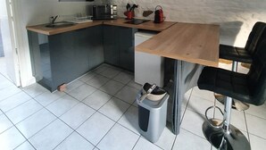 A compact kitchen with a microwave, sink, and a clock on the wall. - Studio "nid Cosy" Avec Piscine Chauffée (Bonnemain)