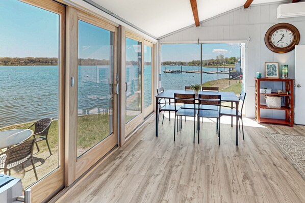 Enjoy a serene lake view from the comfort of this room, featuring a dining area and cozy seating space.