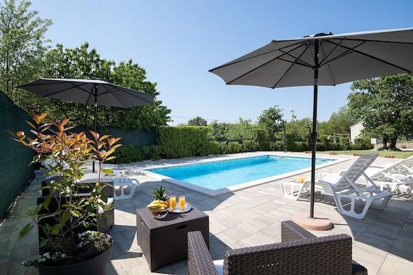 Entspannen Sie im Schatten der Sonnenschirme auf den Liegestühlen der Villa