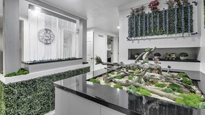 A modern kitchen with a built-in herb garden, a clock on the wall, and a decorative plant arrangement. - Woodsy Retreat in a Quiet Corner of Cuba, with jacuzzi and a theater room (Cuba)