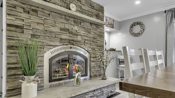 A dining area with a stone fireplace, white chairs, and a table. - Woodsy Retreat in a Quiet Corner of Cuba, with jacuzzi and a theater room (Cuba)