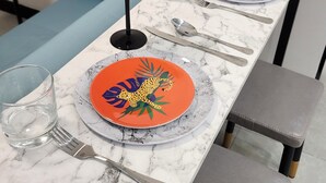 Une table à manger avec deux assiettes, chacune présentant un motif unique, et deux verres à vin.