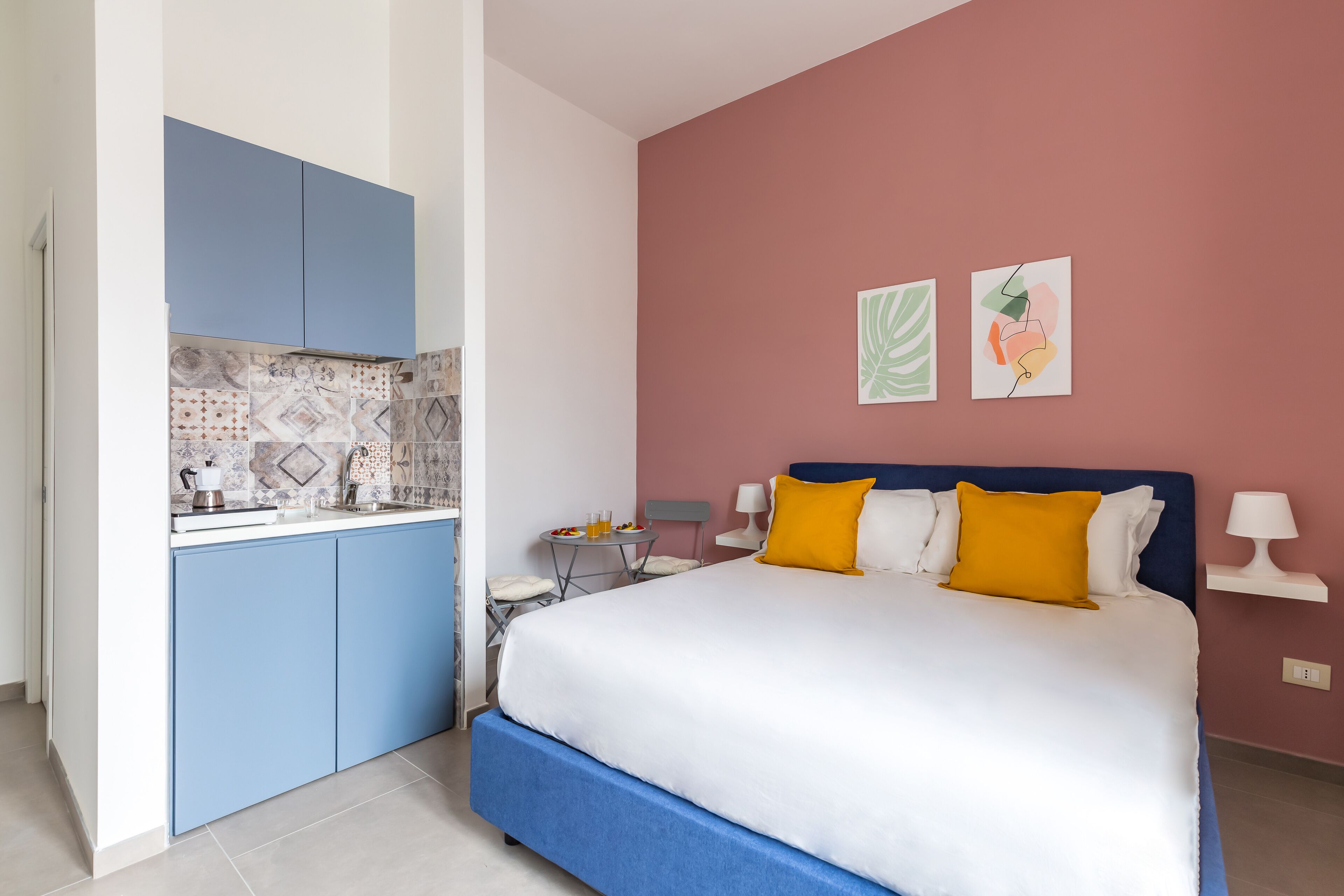A bedroom with a bed, a nightstand, a desk, and a chair.