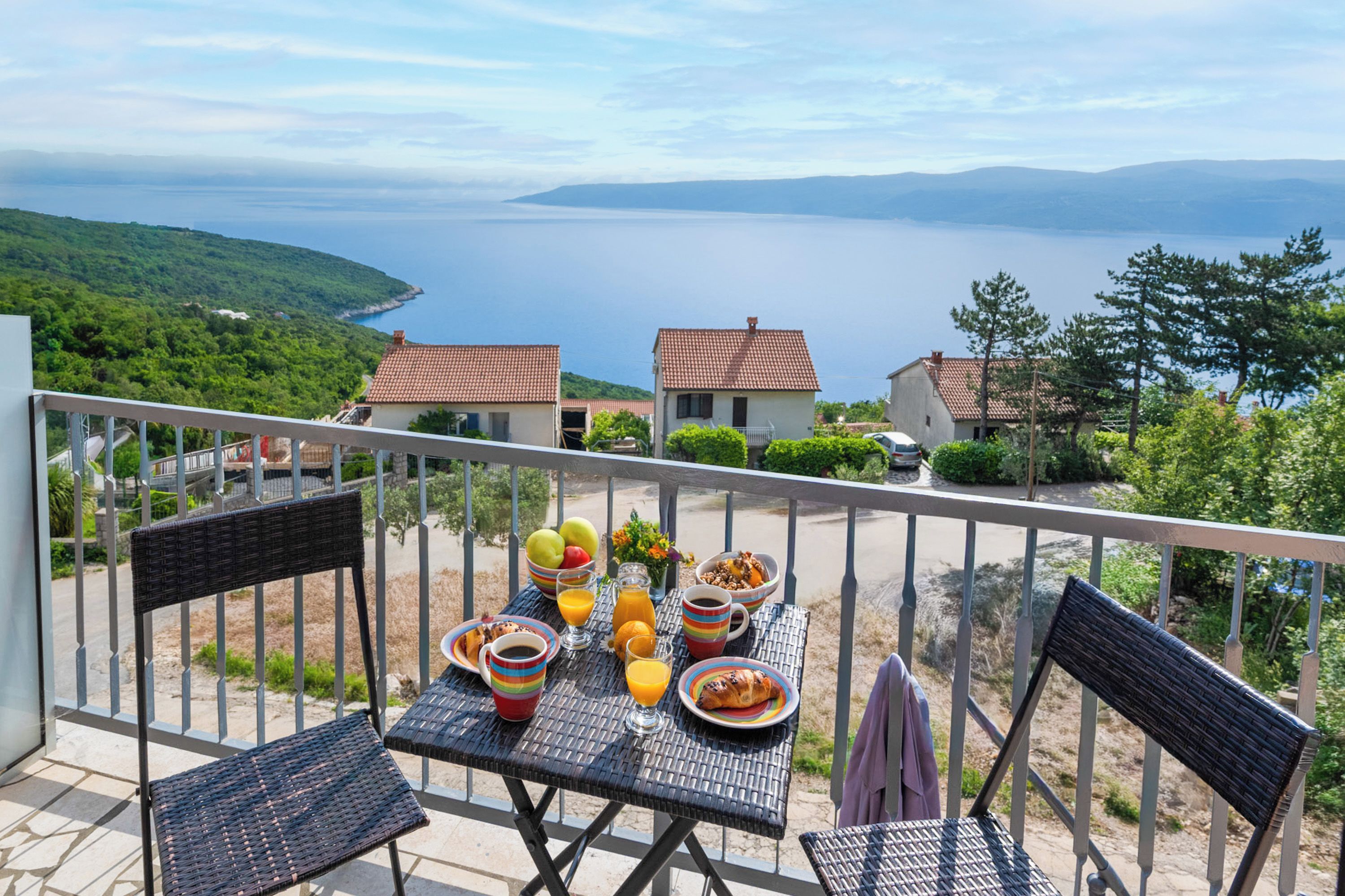 Ein Balkon mit Frühstückstisch und Blick auf die Küste.