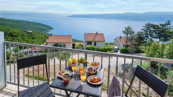 Ein Balkon mit Frühstückstisch und Blick auf die Küste.