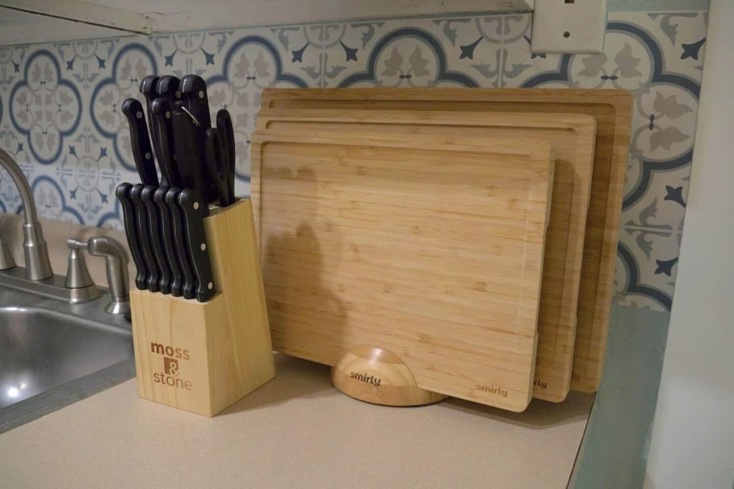 A kitchen counter with a knife block and a cutting board.