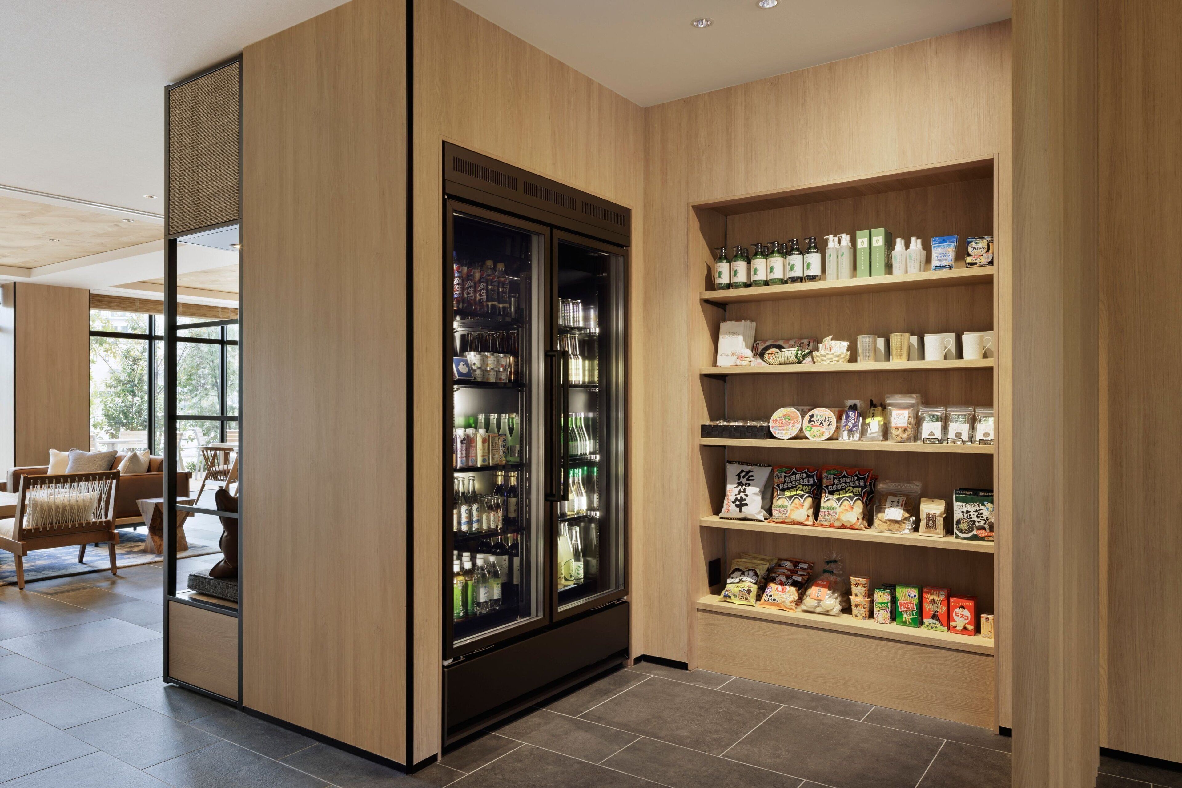 Interior moderno com estante de madeira exibindo diversos alimentos e uma geladeira.