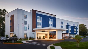A modern hotel with a prominent entrance, multiple floors, and a well-maintained lawn. - Springhill Suites By Marriott Frederica (Frederica)