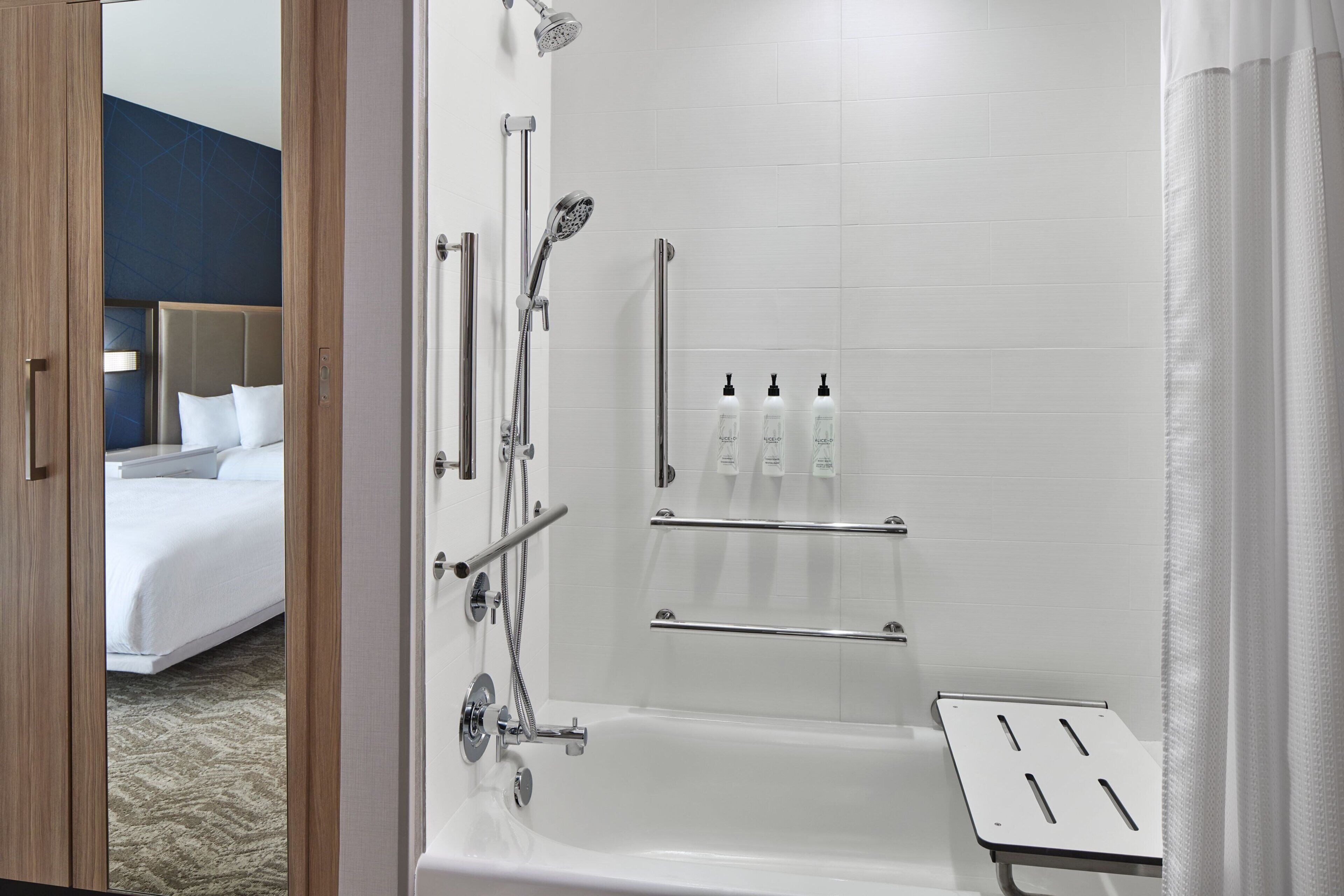 A modern bathroom with a bathtub, shower, and toilet.