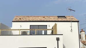 A modern building with a flat roof, a visible window, and an antenna. - Pour 4 Pers Plein Soleil, Gd Terrasse sur Toiture (L'Aiguillon-la-Presqu'île)