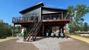 A two-story building with a balcony and a staircase leading to the upper level. - NEW House on Pristine Shell Lake! Right off the ATV/Snowmobile trails! (Shell Lake)