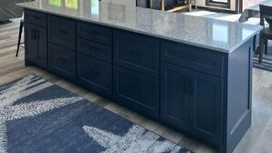 A modern kitchen with dark cabinetry, a granite countertop, pendant lighting, and a view of the outdoors. - NEW House on Pristine Shell Lake! Right off the ATV/Snowmobile trails! (Shell Lake)