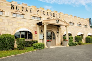 L'esterno dell'hotel Royal Picardie, con architettura classica, caratterizzato da finestre ad arco e un ingresso imponente.