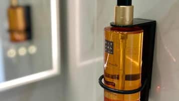 A bottle of liquid soap with a pump dispenser mounted on a wall.