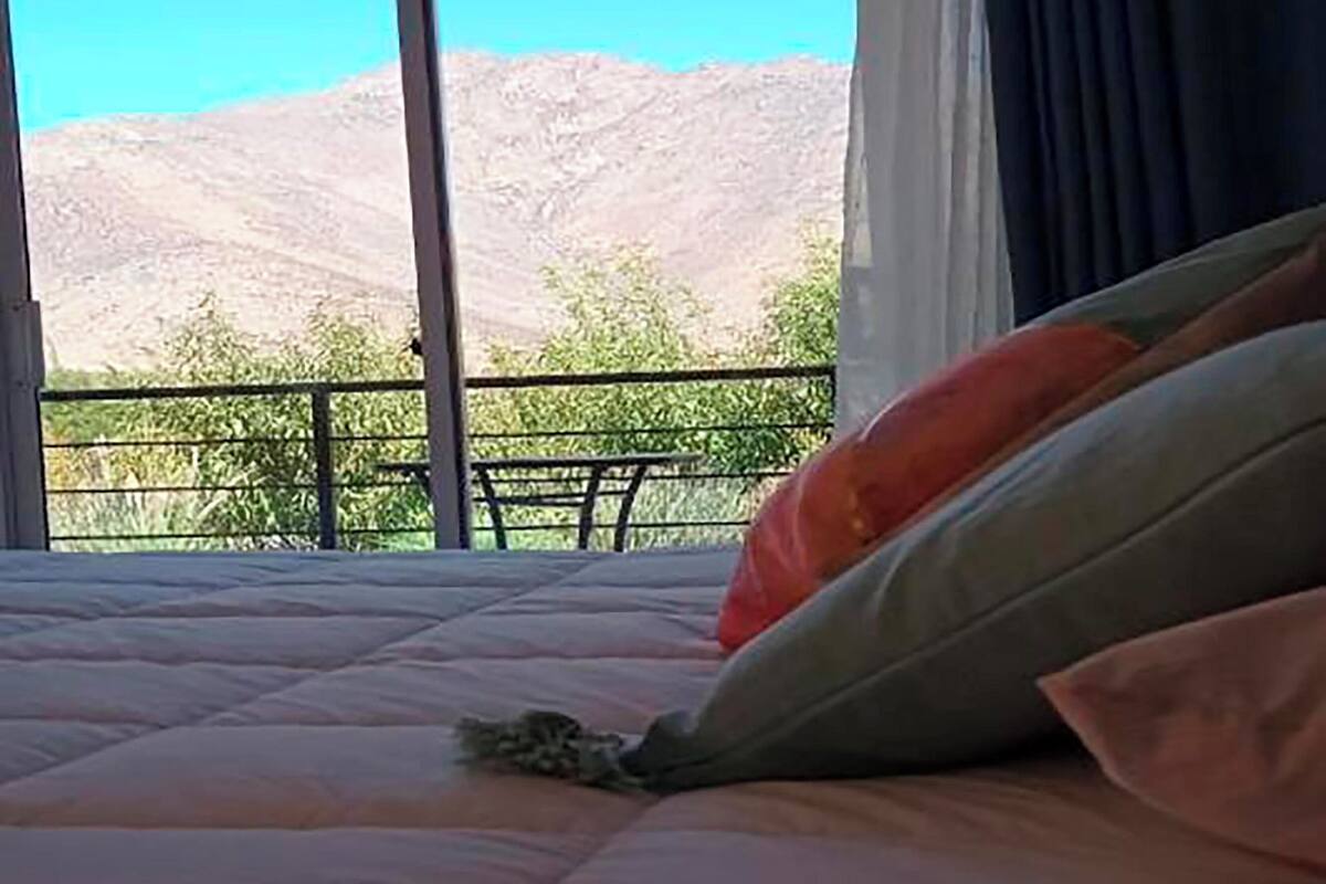 Un lit donnant sur les montagnes, avec une grande fenêtre.