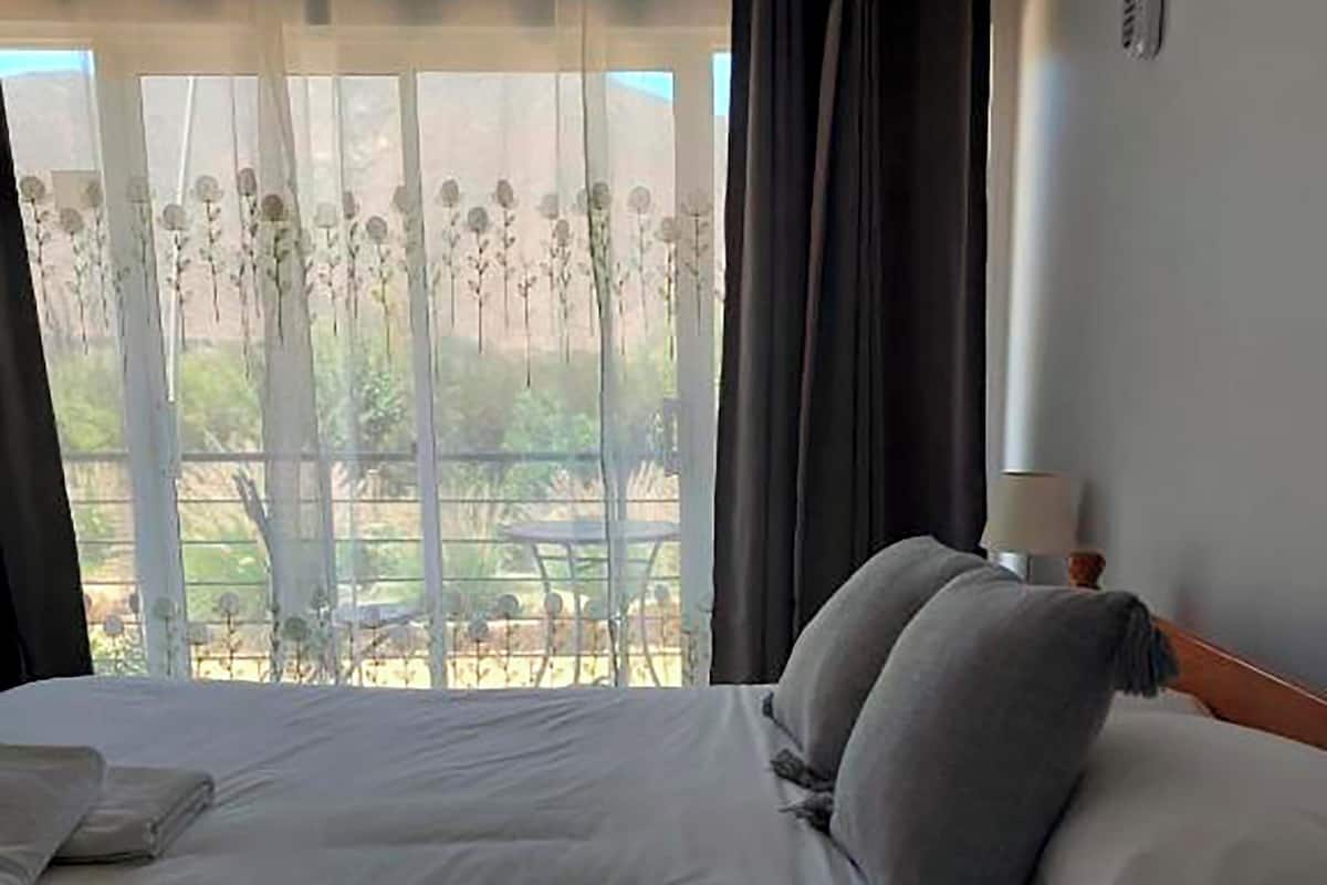 Une chambre d’hôtel avec un lit, une lampe et une vue sur l’extérieur.
