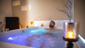 A man relaxing in a hot tub with a candle in the foreground. - Pircas de Arboleda SALAMANCA (Salamanca)