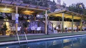 A poolside area with a covered seating area, stone walls, and outdoor furniture. - Pircas de Arboleda SALAMANCA (Salamanca)