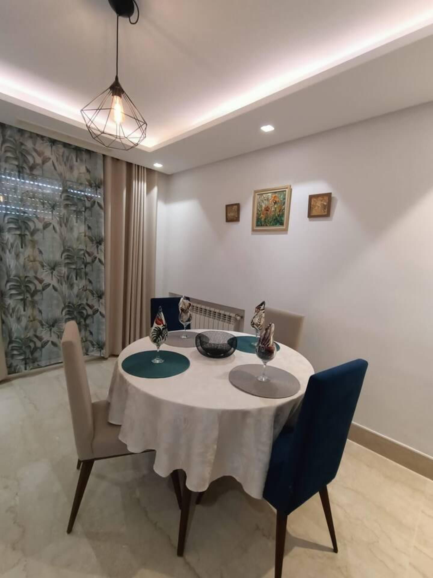 A dining area with a round table, chairs, and decorative items.