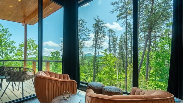 Un interior moderno con amplios ventanales que ofrecen vistas al bosque.