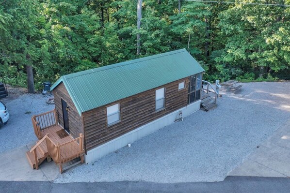 A small cabin with a green roof, a wooden deck, and a gravel driveway. - Lovely Cabin in Bloomington (Bloomington)