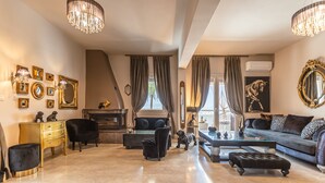Un salon spacieux doté d’une cheminée, de sièges confortables et d’un grand miroir.