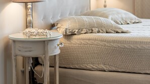 Une chambre à coucher comprenant un lit, une table de chevet avec une lampe et un panneau décoratif mural.