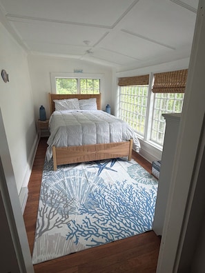 A bedroom with a wooden bed, a nightstand, a window with a view, and a patterned rug. - JUST RENOVATED!!! 3BR 1. 5 Bath Beach Cottage near KPT and Beaches (Kennebunk)