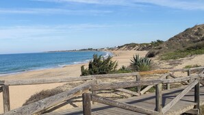 A wooden boardwalk leading to a sandy beach with a clear view of the ocean. - Rota Punta Candor Terrace Playa 3 Bajo C (AN)