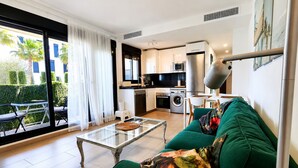 A modern apartment with a dining area, kitchen, and a balcony with a view of greenery. - Rota Punta Candor Terrace Playa 3 Bajo C (AN)