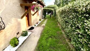 Ein rustikales Gebäude mit einem Gartenweg, der zu einer Holztür führt.
