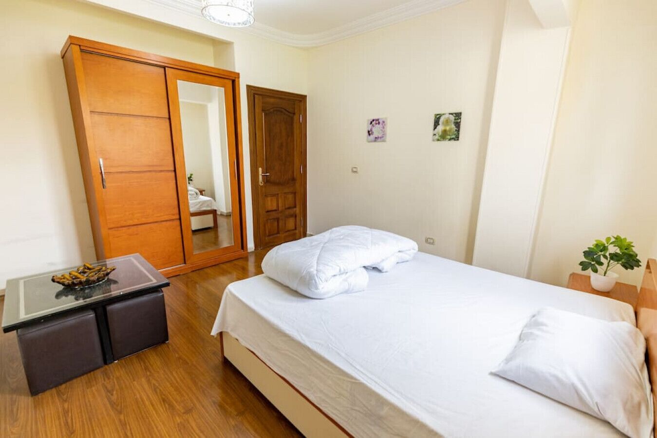 Ein Schlafzimmer mit Bett, Schrank, Schreibtisch und einem kleinen Tisch.