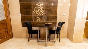 Un espace repas comprenant une table et des chaises, un mur décoratif et une porte en bois.