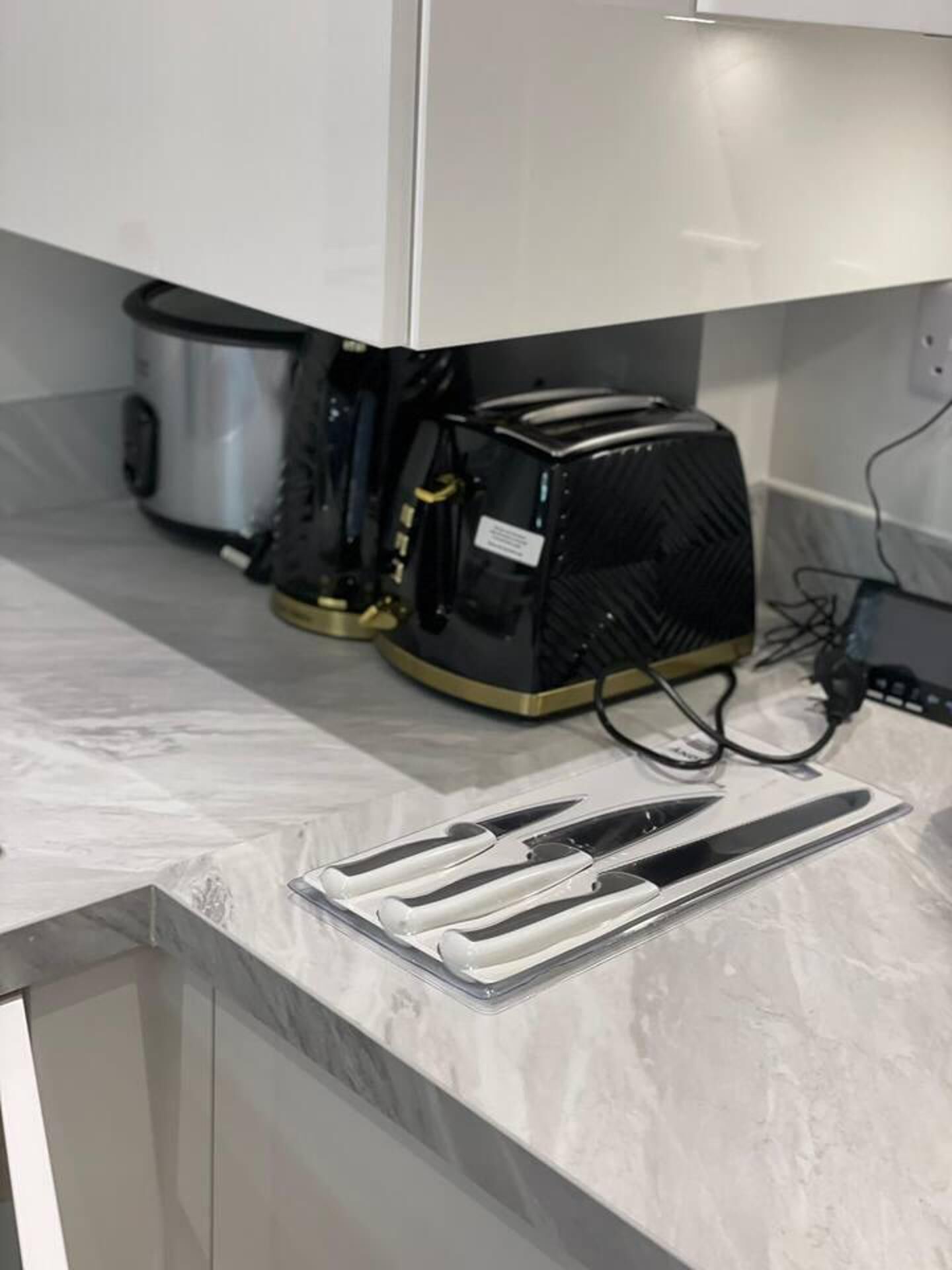 A kitchen with a modern design, featuring a built-in toaster and a coffee maker.