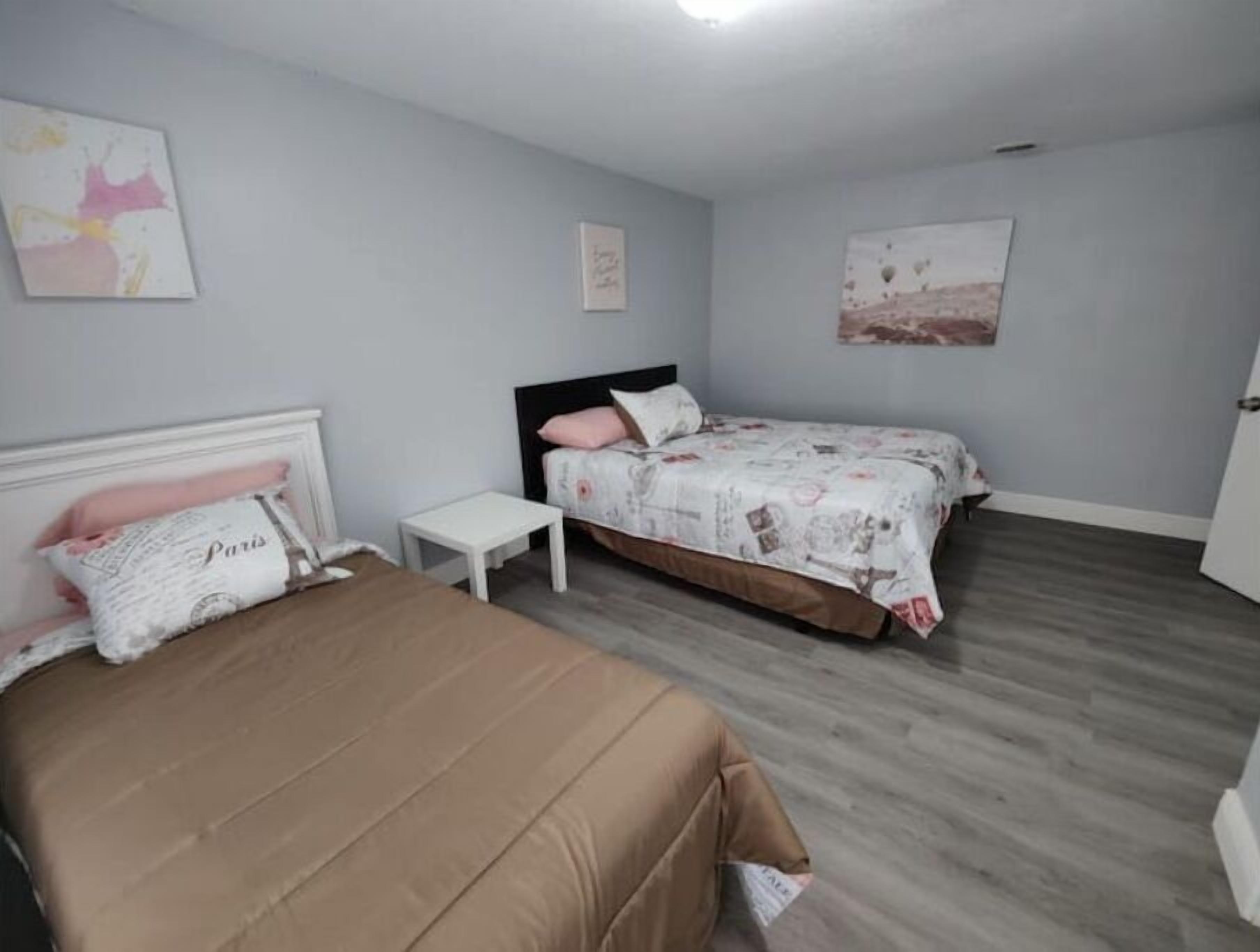 Une chambre avec deux lits, une petite table de chevet et une armoire.