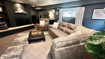 Smart-tv, een open haard, boeken en een printer