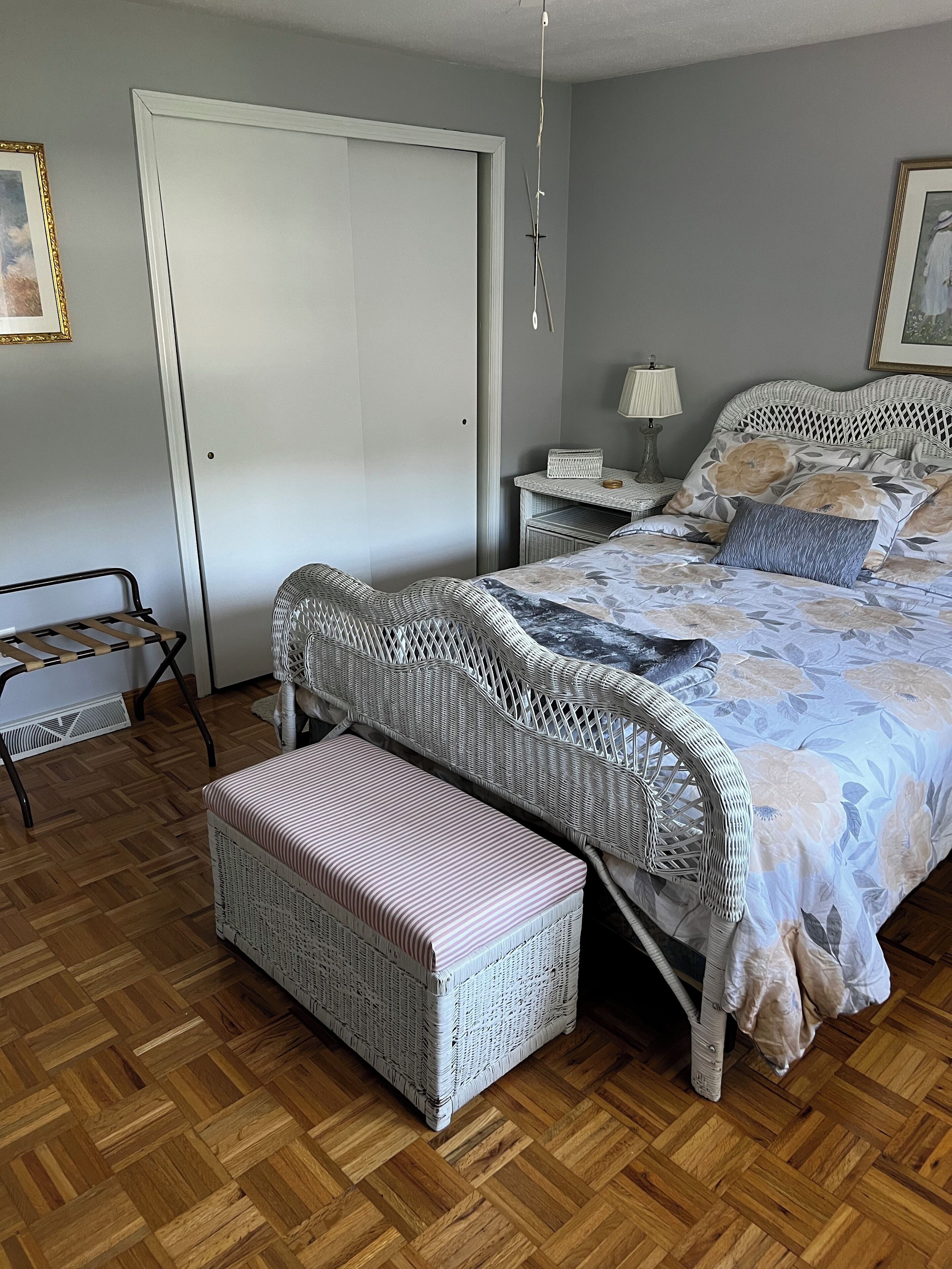 Ein Schlafzimmer mit Bett, Sitzbank, Nachttisch und einer Tür.