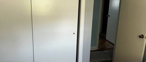 A bedroom with two beds, a wardrobe, and a carpeted floor.