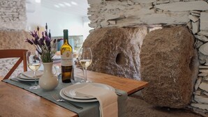 A dining table set with plates, glasses, a wine bottle, and a vase with flowers. - Casa do Santo - Wine & Tourism (Sabrosa)