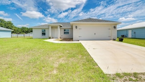 A single-story house with a garage, a front yard, and a clear sky.