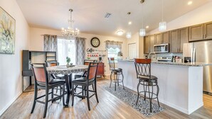 A modern kitchen with a central island, stainless steel appliances, and pendant lighting.