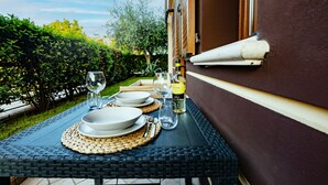 An outdoor dining area with a table set for two, including plates, cutlery, and a wine glass. - Martilla - Two Bedroom Apartment, Sleeps 5 (Gabicce Mare)