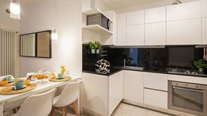 A modern kitchen with white cabinets, a black countertop, and a built-in oven. - Martilla - Two Bedroom Apartment, Sleeps 5 (Gabicce Mare)