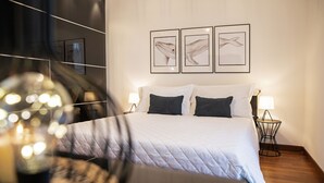 A neatly arranged bedroom with a large bed, two bedside tables with lamps, and three framed whale illustrations on the wall. - Martilla - Two Bedroom Apartment, Sleeps 5 (Gabicce Mare)