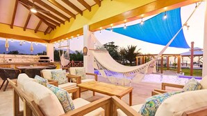 An outdoor seating area with wooden furniture and a hammock. - Spectacular oceanfront home (Omoa)