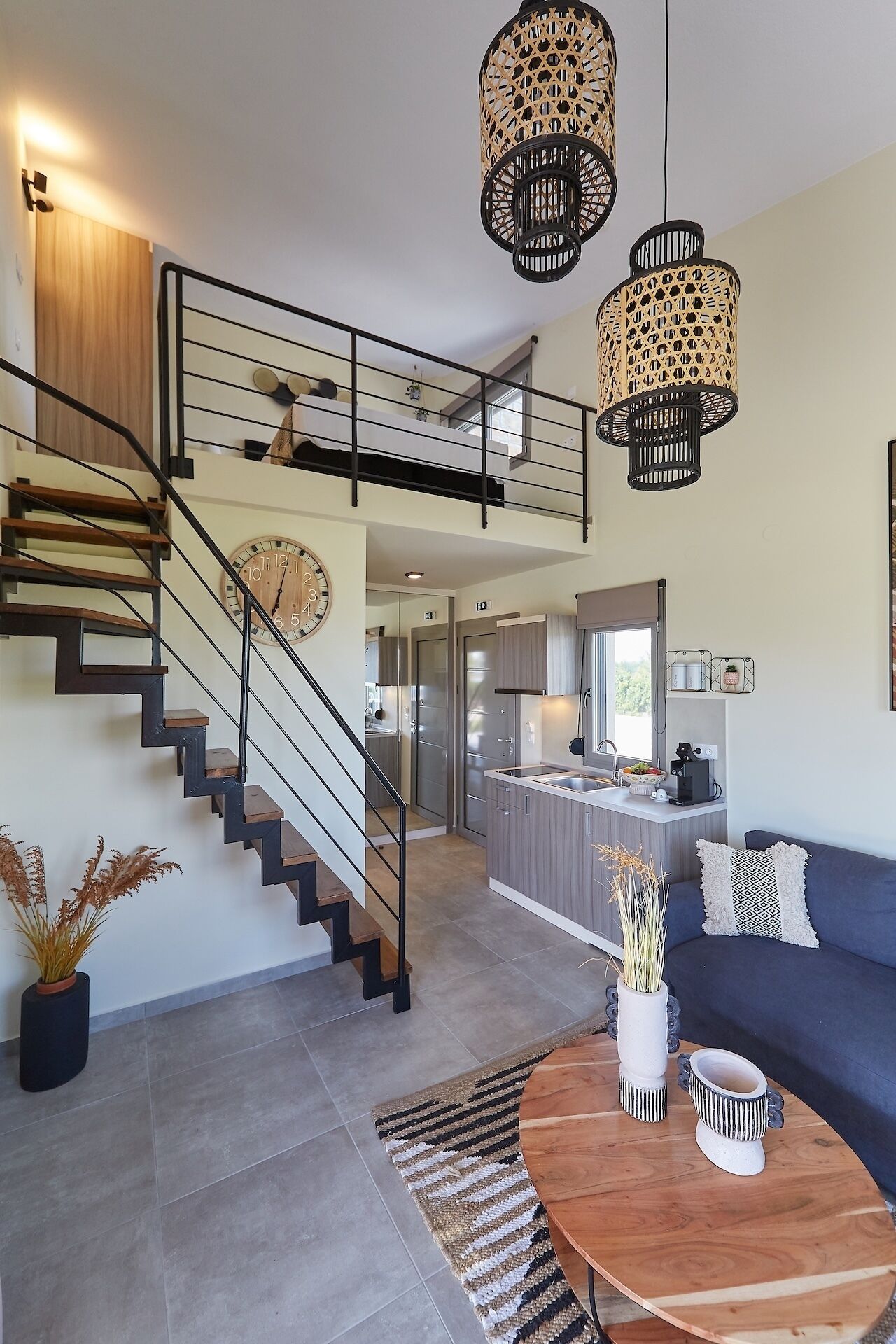 A modern interior with a staircase, living room, kitchen, and dining area.