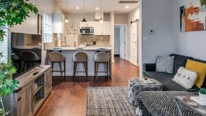 A modern apartment with a kitchen, dining area, and living room.