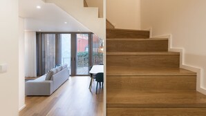 Ein modernes Interieur mit Treppe, einer Couch und einem Essbereich.