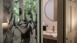 Ein Badezimmer mit rundem Spiegel, Waschbecken und Schrank.