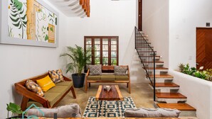 A spacious living area with a sofa set, a coffee table, and a staircase. - VICA GUEST HOUSE (Cancun)